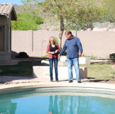Doug Hopkins and Shari Pozniak admire the finished swimming pool at this property. How much value does a swimming pool add to a home? Watch Property Wars to find out!