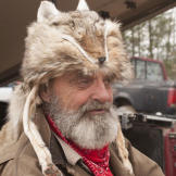 Trapper wears a fur hat.